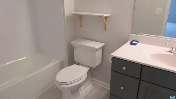 a white toilet sitting next to a bath tub