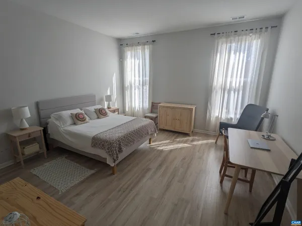 a bedroom with a bed and wooden floor
