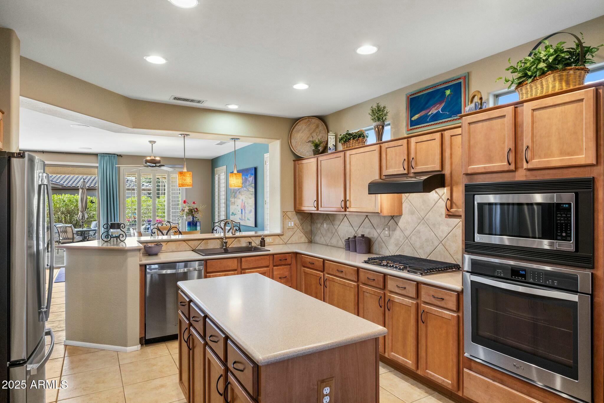 20139 North Rawhide Way Surprise, AZ 85387 - Photo 11 of 30 a kitchen with stainless steel appliances granite countertop a sink a stove and a refrigerator
