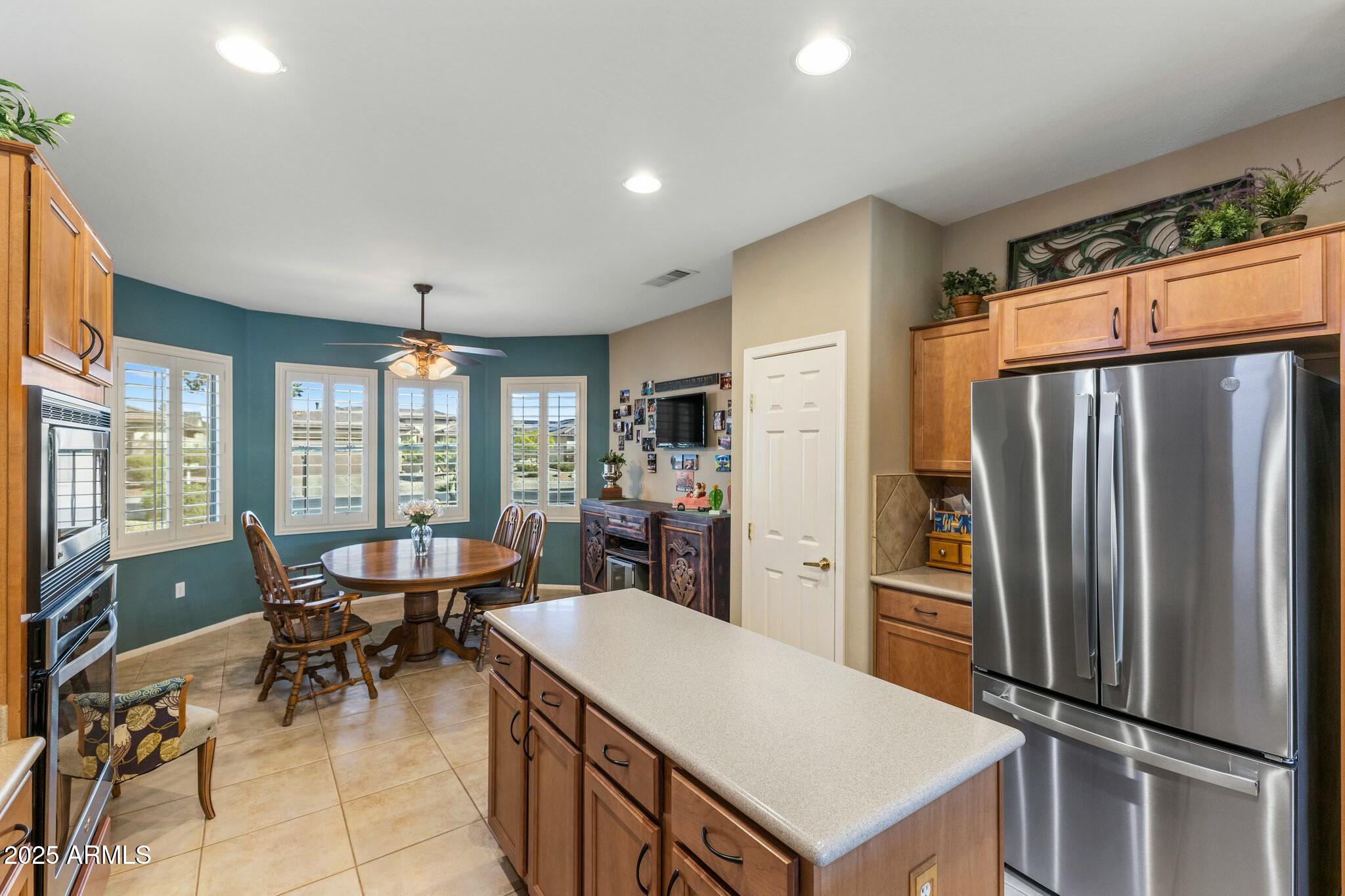 20139 North Rawhide Way Surprise, AZ 85387 - Photo 9 of 30 a kitchen with stainless steel appliances a dining table chairs refrigerator and sink
