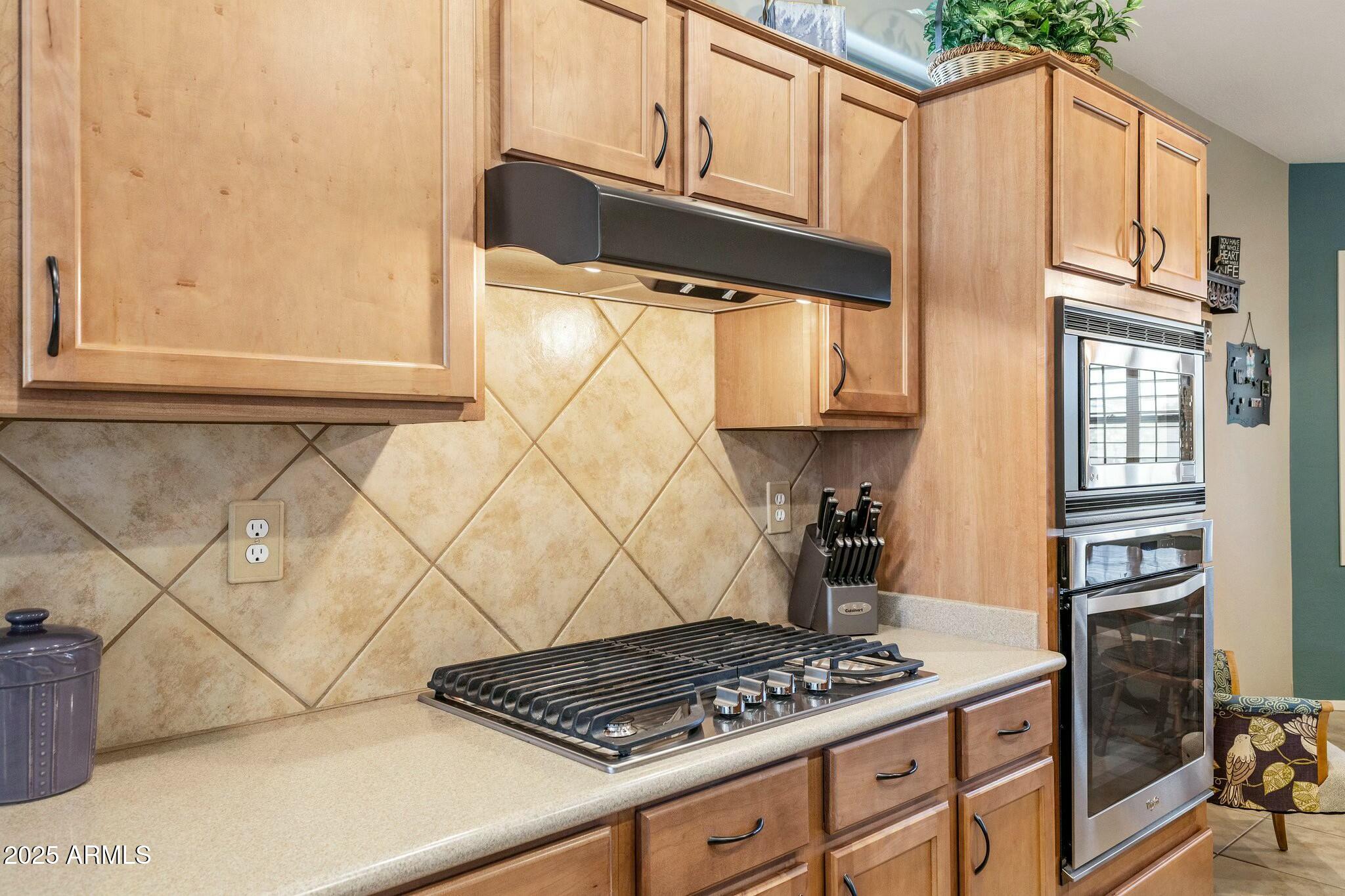 20139 North Rawhide Way Surprise, AZ 85387 - Photo 10 of 30 a kitchen with granite countertop a stove and a wooden cabinets