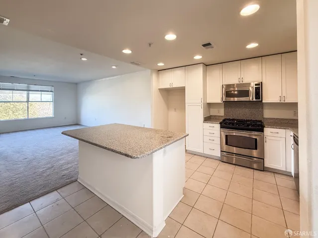 a kitchen with granite countertop a stove and a refrigerator