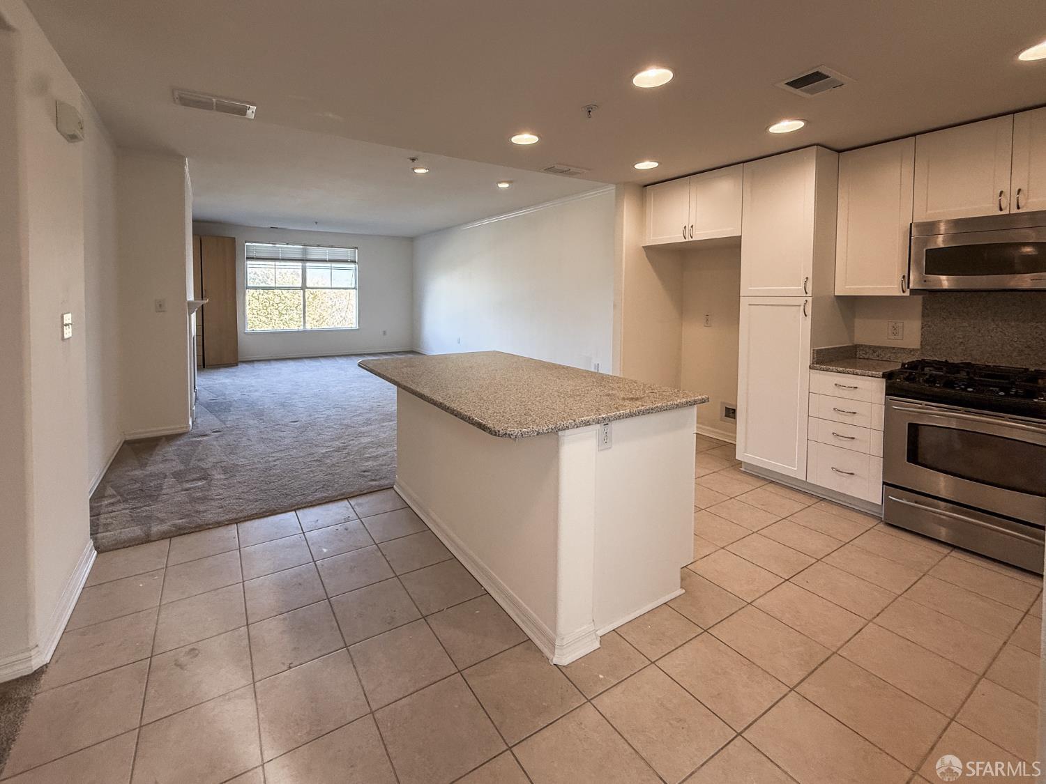 3901 Lick Mill Boulevard, Unit 312 Santa Clara, CA 95054 - Photo 5 of 18 a kitchen with kitchen island granite countertop a stove a sink and a refrigerator