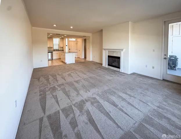 a view of empty room with a fireplace and wooden floor