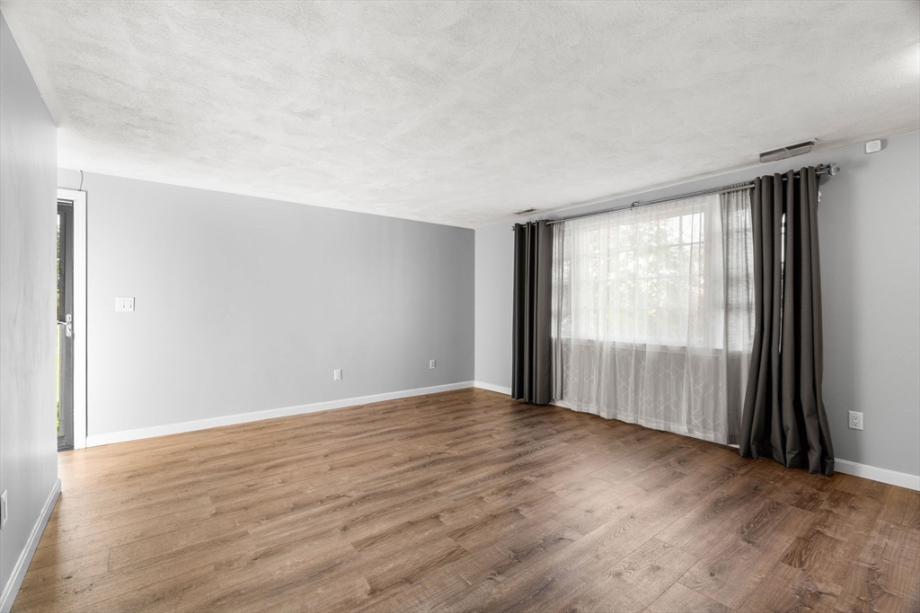 20 Washington Street, Unit 54 Methuen, MA 01844 - Photo 16 of 27 an empty room with wooden floor and windows