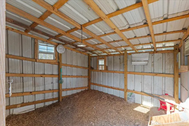 a backyard of a house with large trees and plants