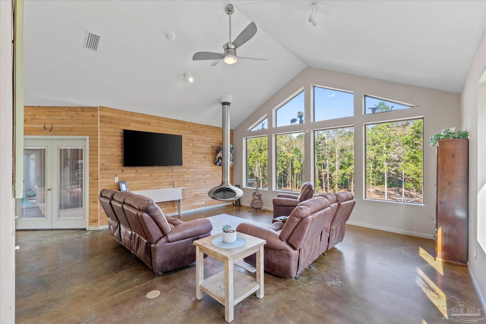 4394 Crabtree Church Road Molino, FL 32577 - Photo 10 of 70 a living room with furniture floor to ceiling window hardwood floor and a flat screen tv