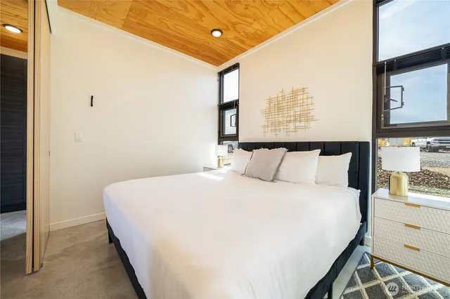 a large bed in a bedroom next to a window