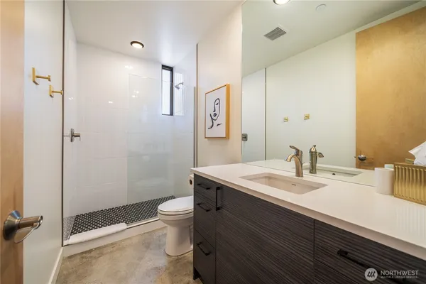 a bathroom with a sink a toilet and shower