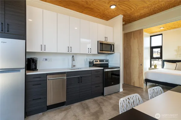 a kitchen with stainless steel appliances granite countertop a sink dishwasher stove refrigerator and cabinets