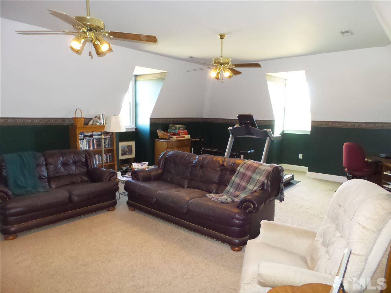 2915 Green Path Road Dunn, NC 28334 - Photo 13 of 24 a living room with furniture a fireplace and a chandelier