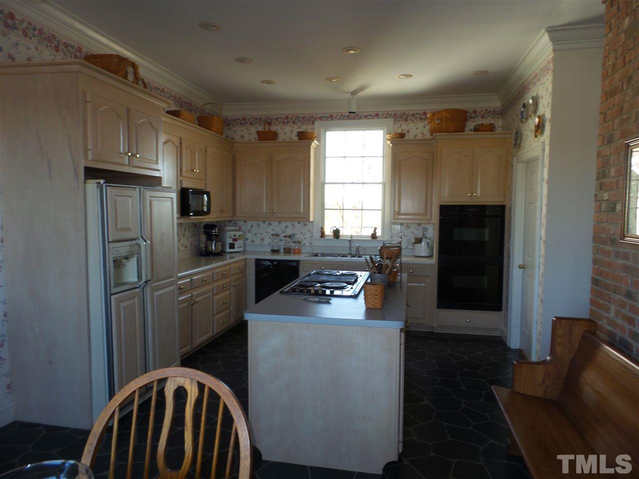 2915 Green Path Road Dunn, NC 28334 - Photo 7 of 24 a kitchen with a sink a refrigerator a stove a washer dryer and a window