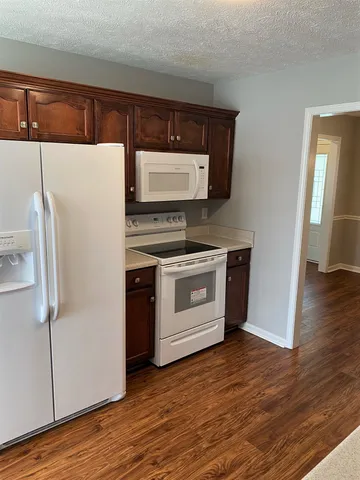 a kitchen with a stove refrigerator and microwave