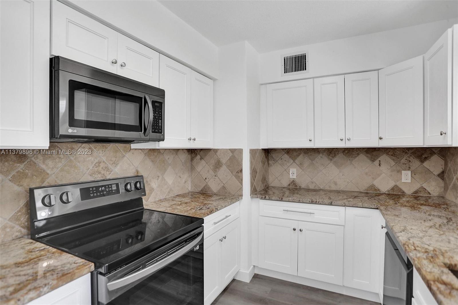 6842 Northwest 13th Street Plantation, FL 33313 - Photo 11 of 33 a kitchen with granite countertop white cabinets and stainless steel appliances