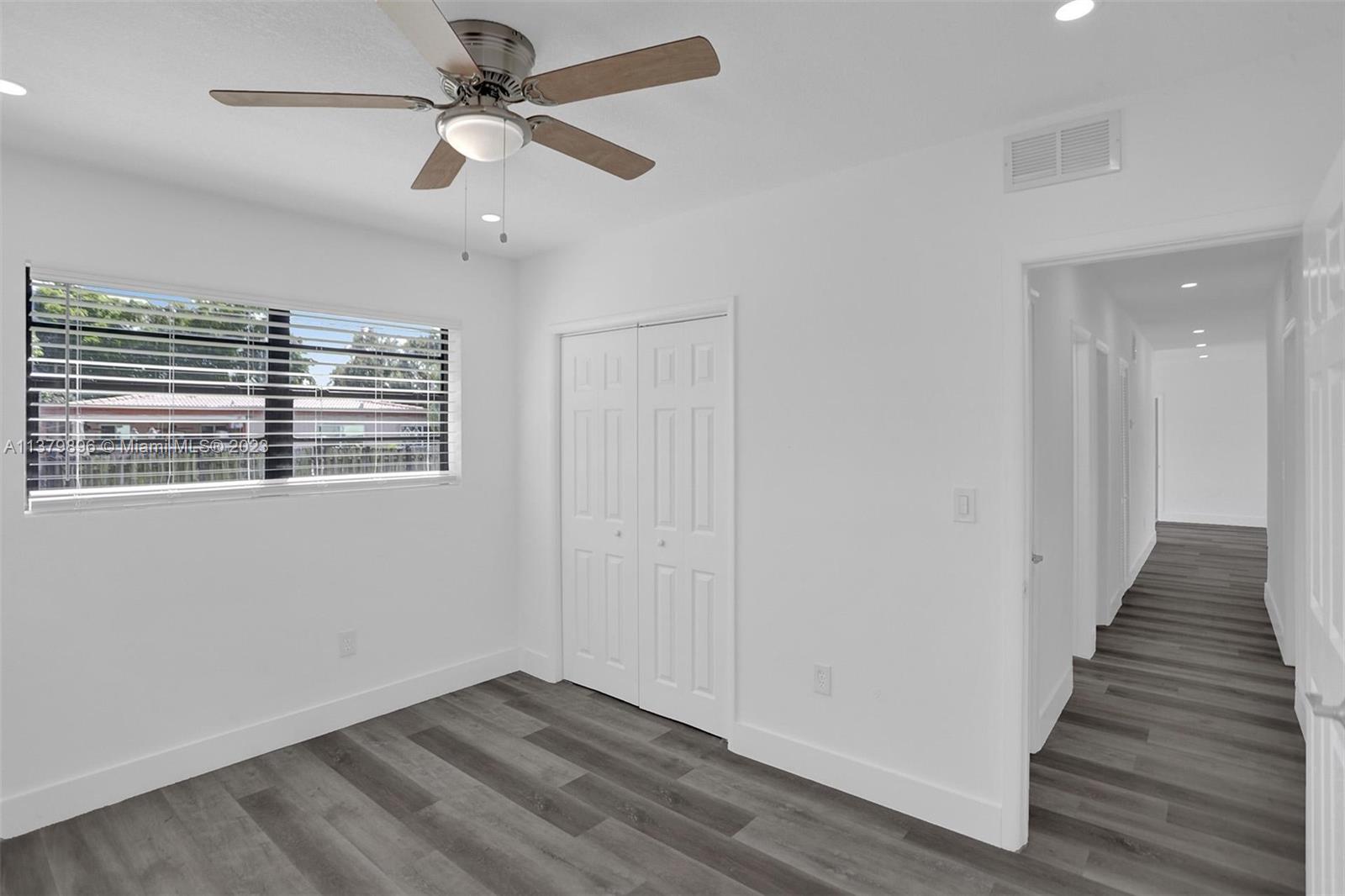 6842 Northwest 13th Street Plantation, FL 33313 - Photo 26 of 33 a view of an empty room with wooden floor and a ceiling fan
