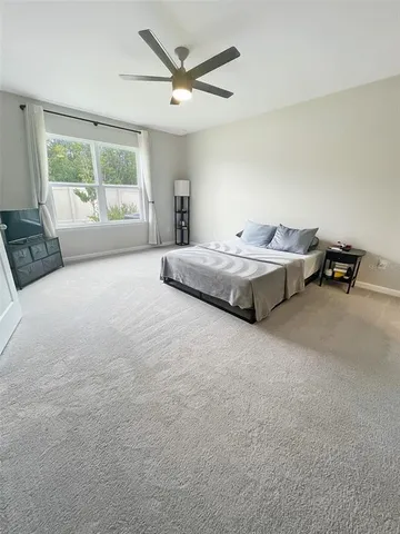 a spacious bedroom with a bed and wooden floor