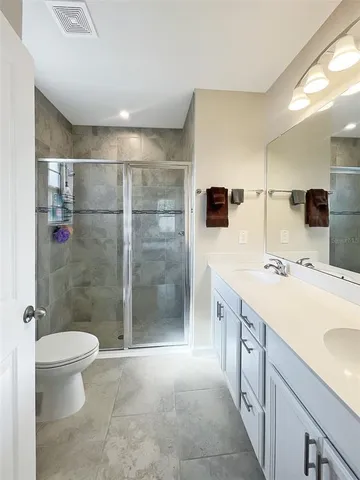 a bathroom with a double vanity sink toilet and shower