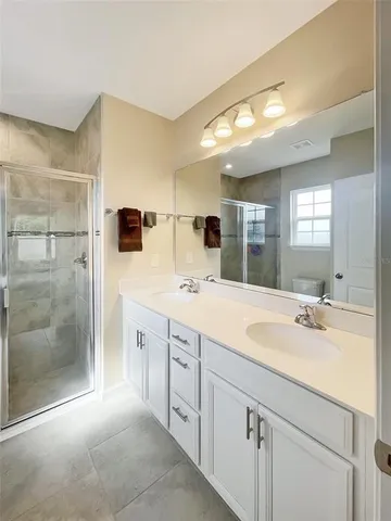 a spacious bathroom with a shower sink and mirror