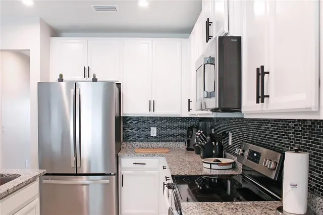 a kitchen with a refrigerator a stove a sink and a cabinets