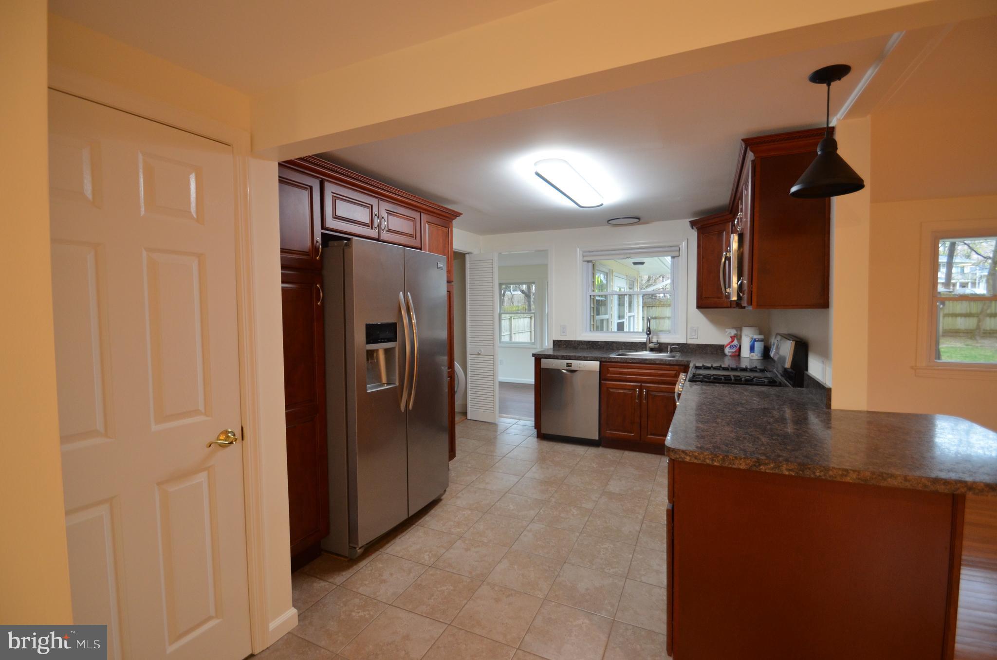 49 Wallace Road Princeton Junction, NJ 08550 - Photo 5 of 32 a kitchen with stainless steel appliances granite countertop a refrigerator a sink a stove and a refrigerator with wooden floor