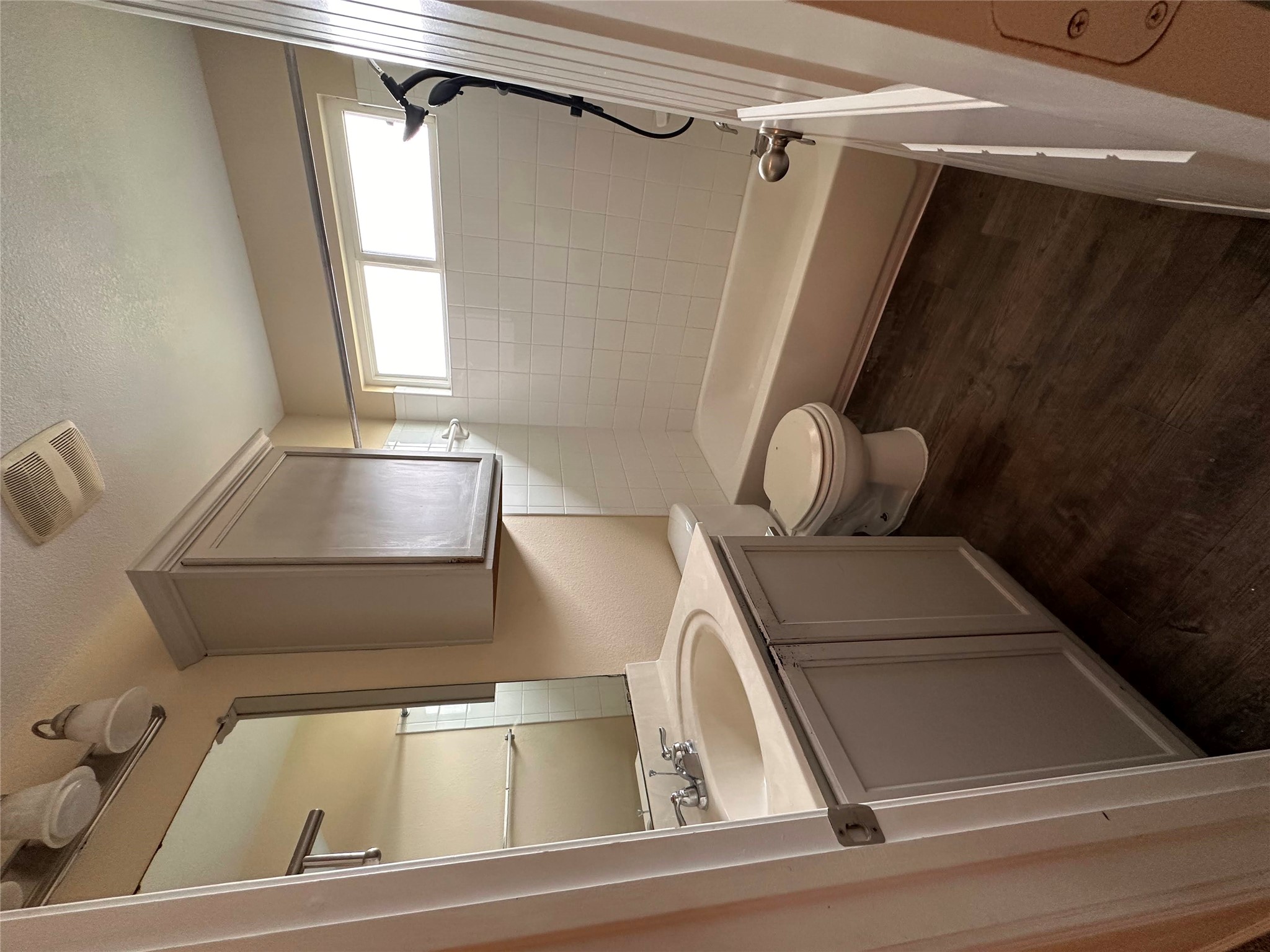 207 Liard River Road Hutto, TX 78634 - Photo 15 of 25 Full bath with vanity, dark wood-style floors, bathing tub / shower combination, and a textured ceiling