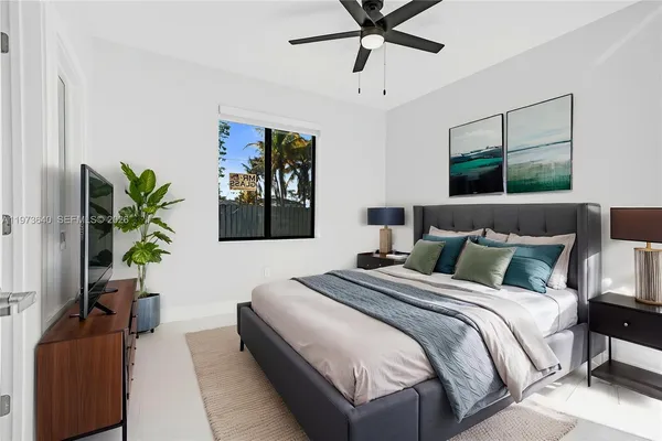 a bedroom with a large bed and a potted plant