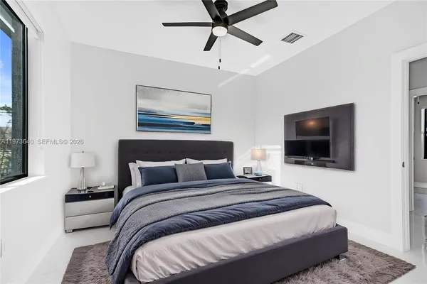 a bedroom with a bed and a flat screen tv