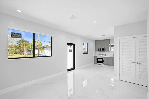 a large white kitchen with a refrigerator a stove a sink and a cabinets