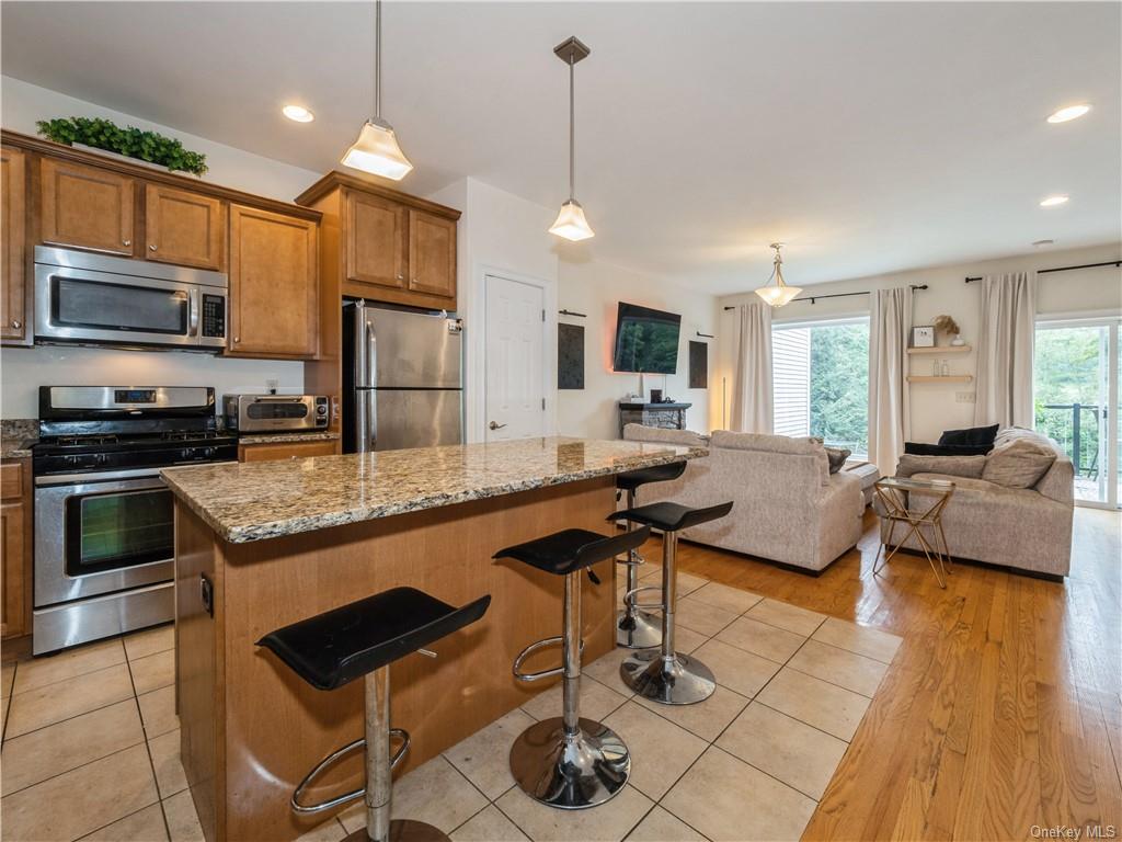 6-8 Wilbur Road Pleasant Valley, NY 12569 - Photo 14 of 36 Kitchen featuring a kitchen breakfast bar, light wood-type flooring, stainless steel appliances, and hanging light fixtures