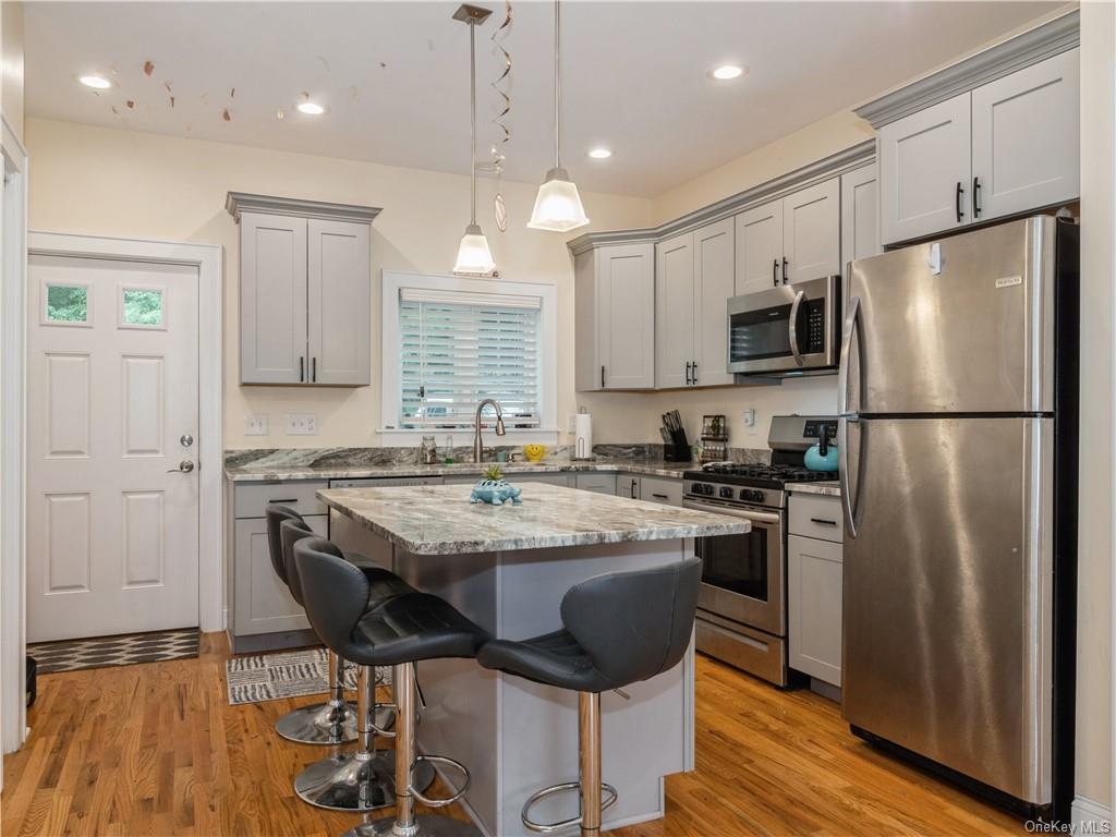 6-8 Wilbur Road Pleasant Valley, NY 12569 - Photo 32 of 36 Kitchen with light wood-type flooring, appliances with stainless steel finishes, a kitchen island, and pendant lighting