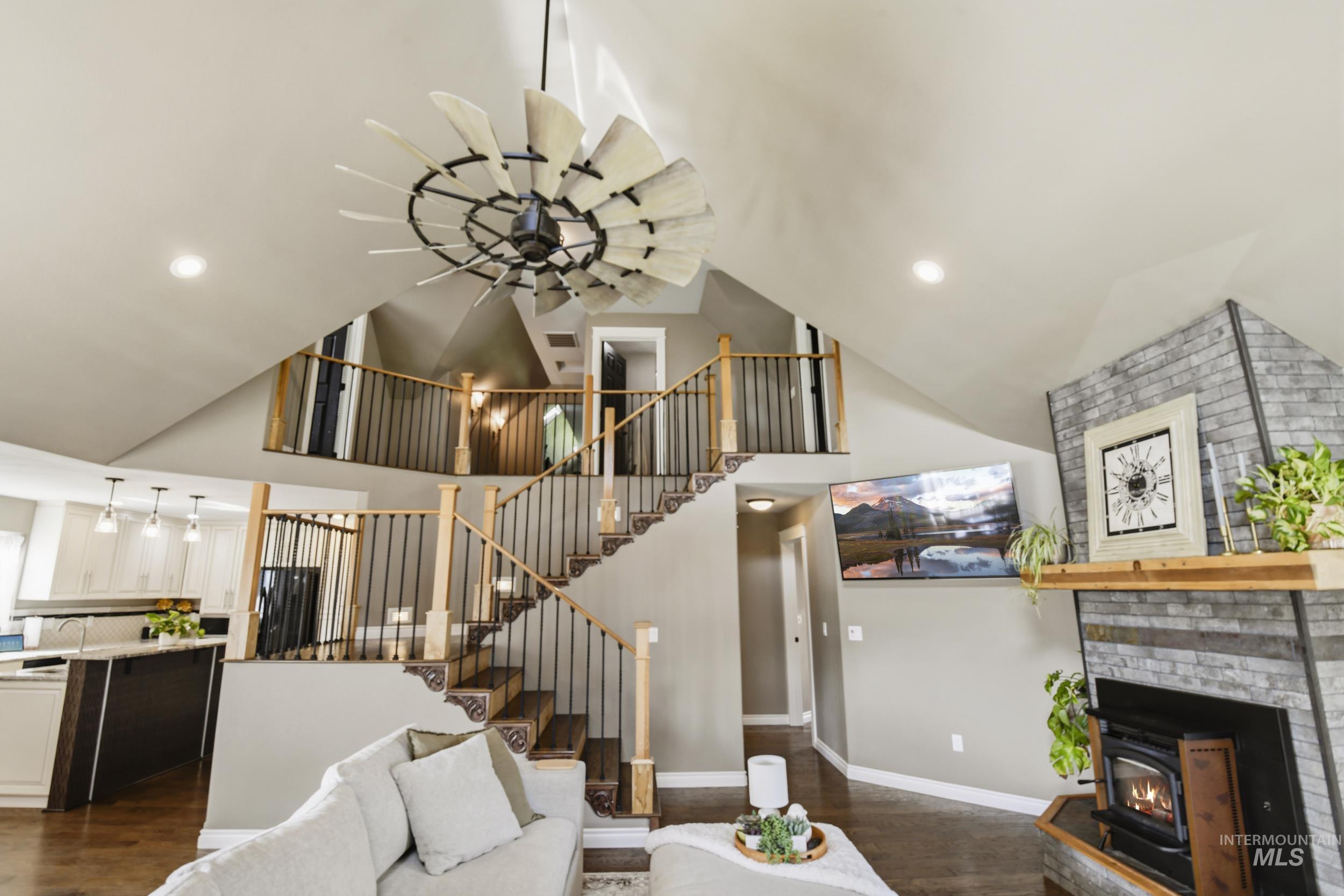301 State Street Juliaetta, ID 83535 - Photo 11 of 41 Living area featuring dark wood-style floors, ceiling fan, lofted ceiling, a wood stove, and recessed lighting