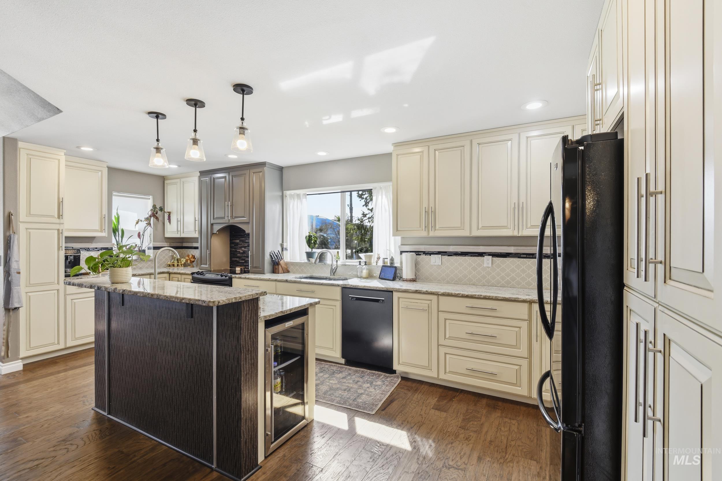 301 State Street Juliaetta, ID 83535 - Photo 17 of 41 Kitchen with cream cabinets, light stone countertops, black appliances, and dark wood-type flooring