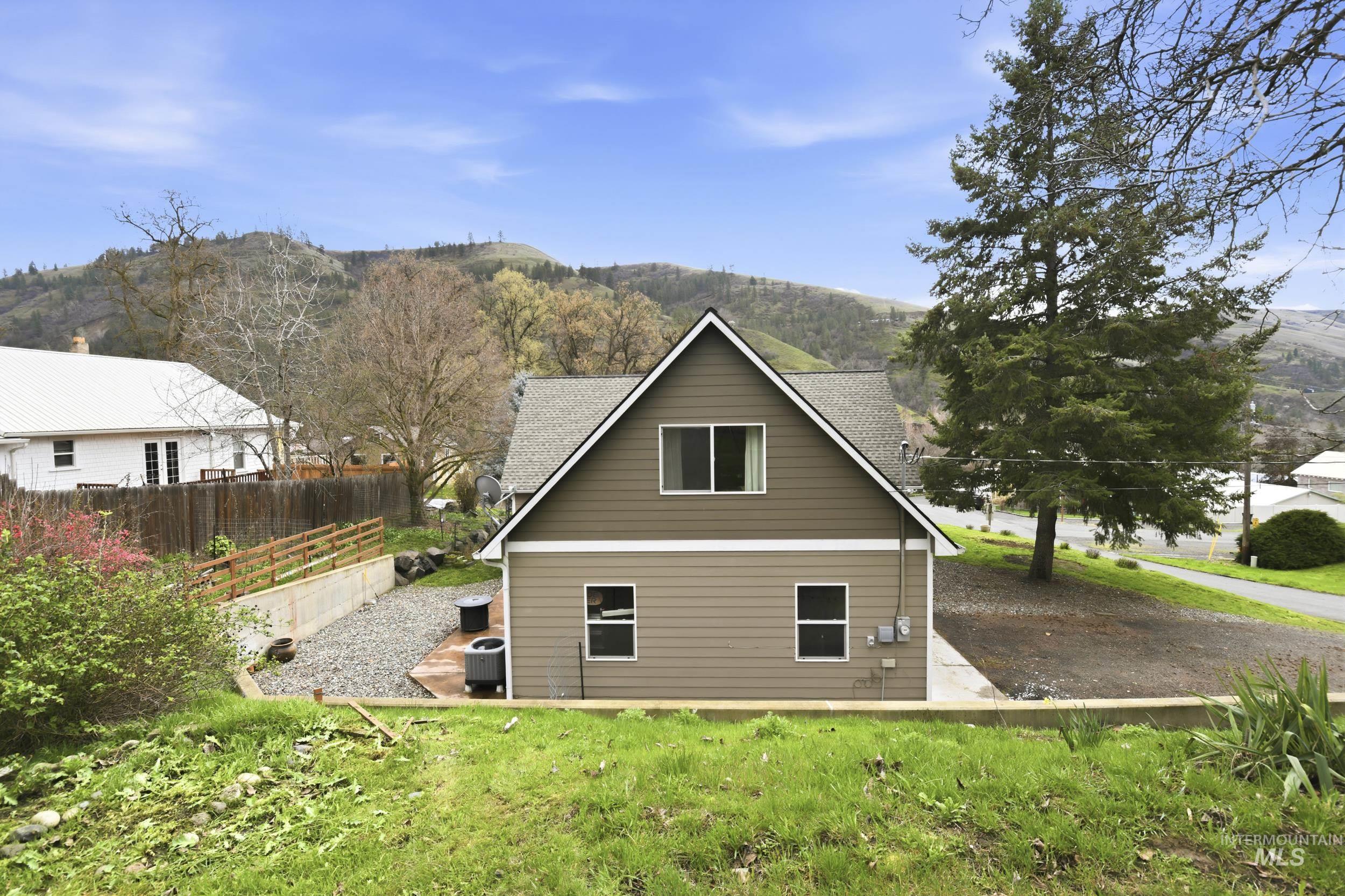 301 State Street Juliaetta, ID 83535 - Photo 35 of 41 Rear view of house featuring roof with shingles and a mountain view