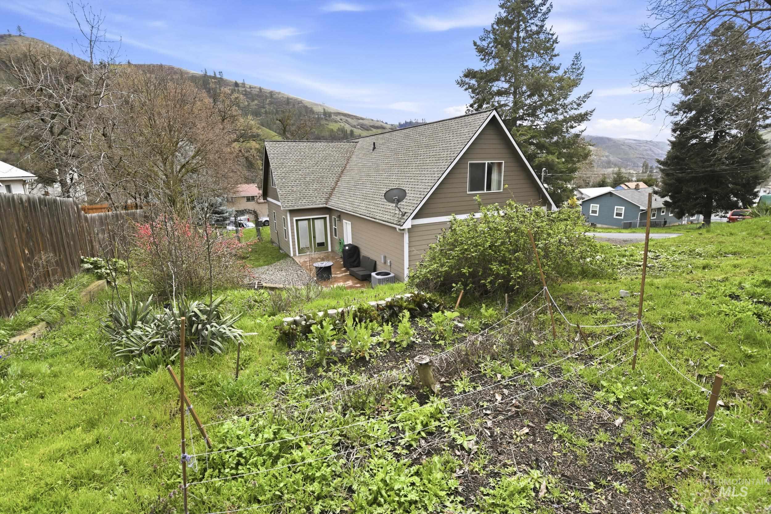 301 State Street Juliaetta, ID 83535 - Photo 36 of 41 View of side of home featuring a patio, a mountain view, and a shingled roof