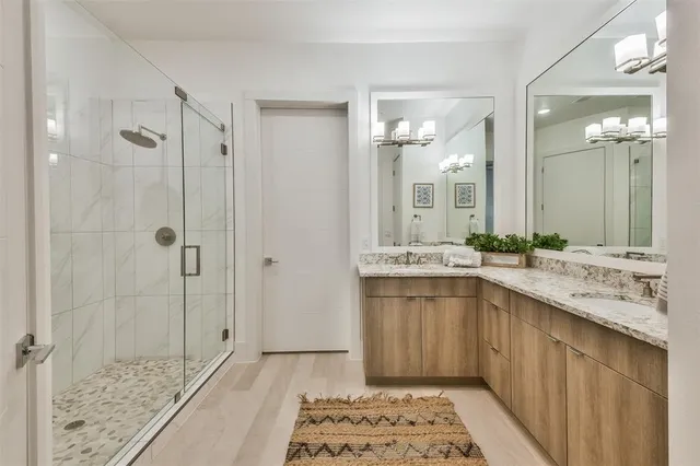 a bathroom with a double vanity sink mirror and shower