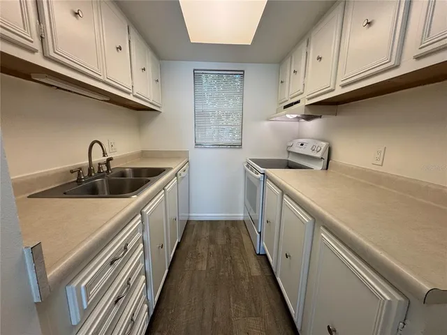 a kitchen with a sink a stove and cabinets