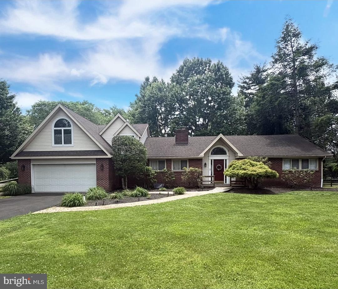 333 Spring House Road Newtown, PA 18940 - Photo 1 of 1 a front view of a house with a garden and trees