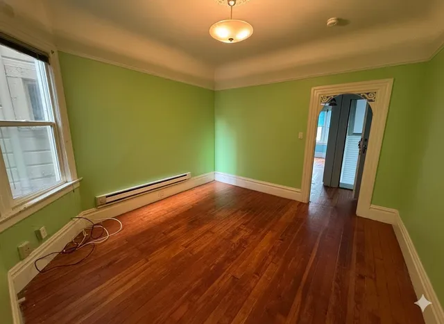 a view of room with window and wooden floor