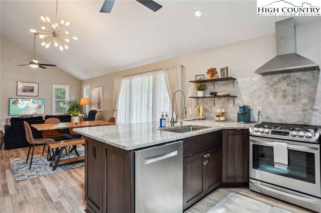 909 Niley Cook Road Blowing Rock, NC 28605 - Photo 31 of 45 a kitchen with a stove a sink dishwasher and a dining table with wooden floor