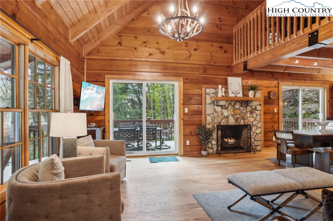909 Niley Cook Road Blowing Rock, NC 28605 - Photo 7 of 45 a living room with furniture a fireplace and a chandelier