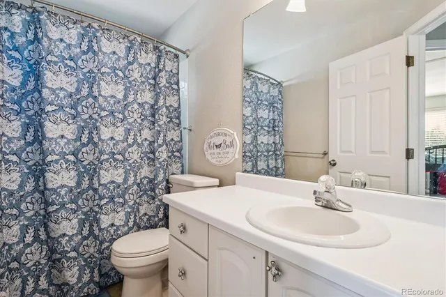 a bathroom with a sink toilet and a mirror