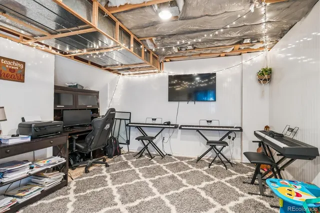 a work room with furniture and a flat screen tv