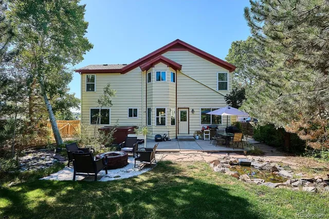 a view of a house with backyard and sitting area