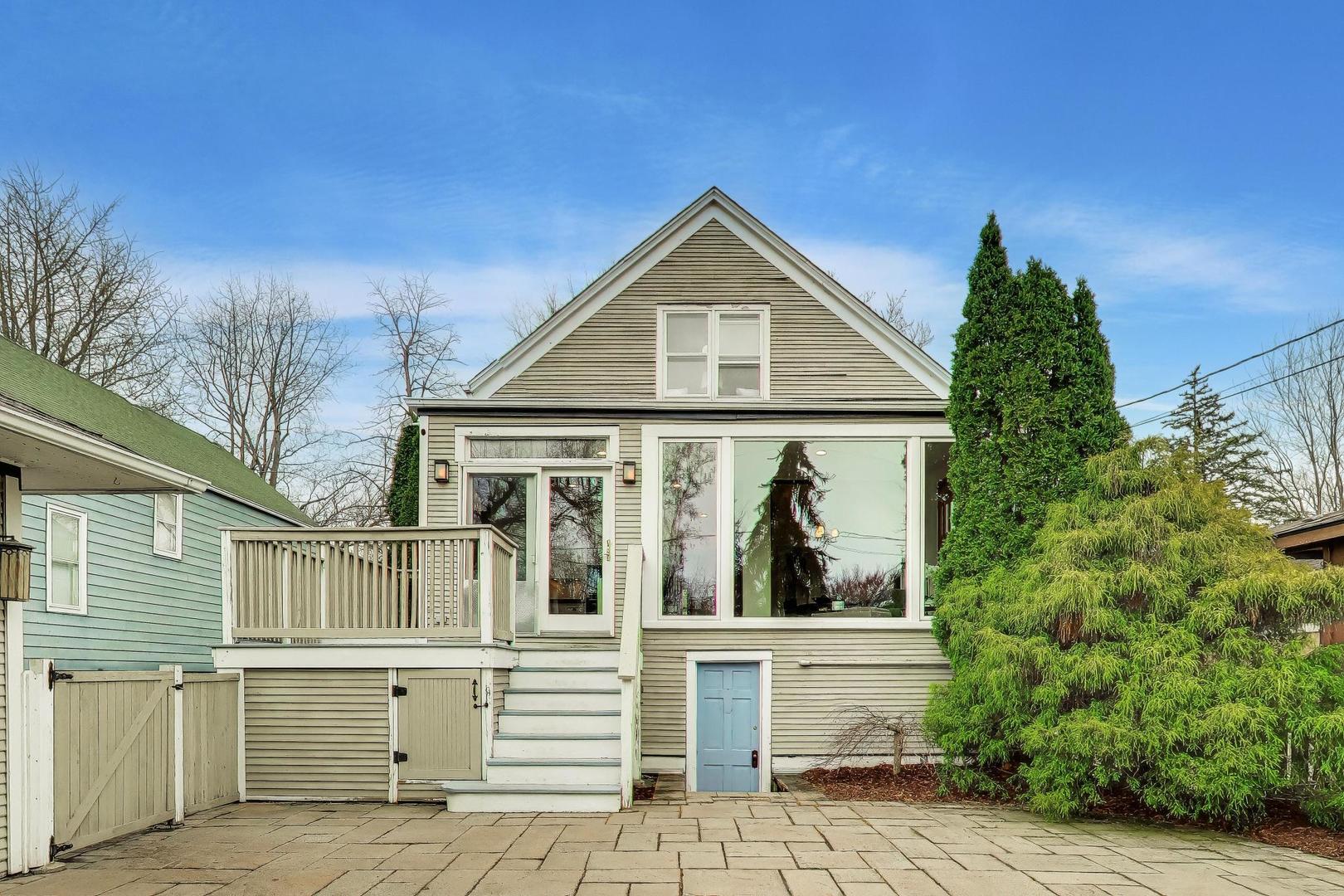 256 Blackhawk Road Riverside, IL 60546 - Photo 48 of 73 a view of a white house with large windows and a small yard