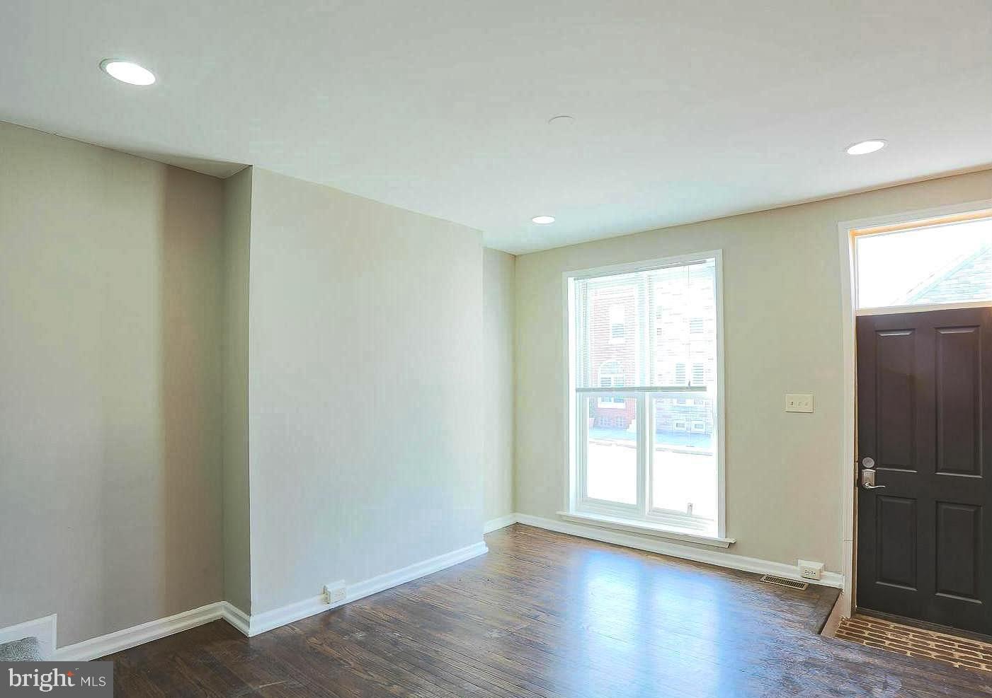 1114 West Cross Street Baltimore, MD 21230 - Photo 14 of 19 a view of an empty room with wooden floor and a window