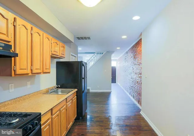 a kitchen with stainless steel appliances granite countertop a sink a stove and a refrigerator