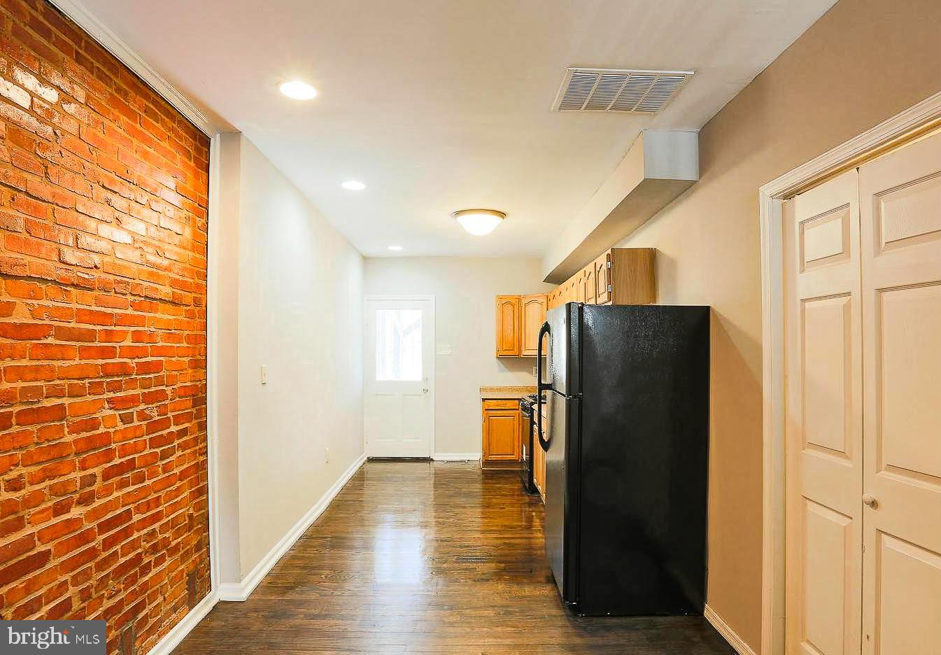 1114 West Cross Street Baltimore, MD 21230 - Photo 10 of 19 a view of a livingroom with wooden floor and a refrigerator