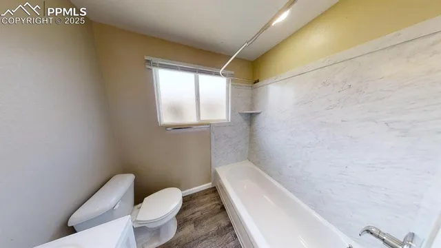 a white toilet sitting next to a bath tub