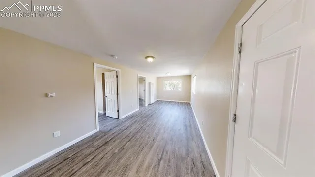 a view of a hallway with wooden floor
