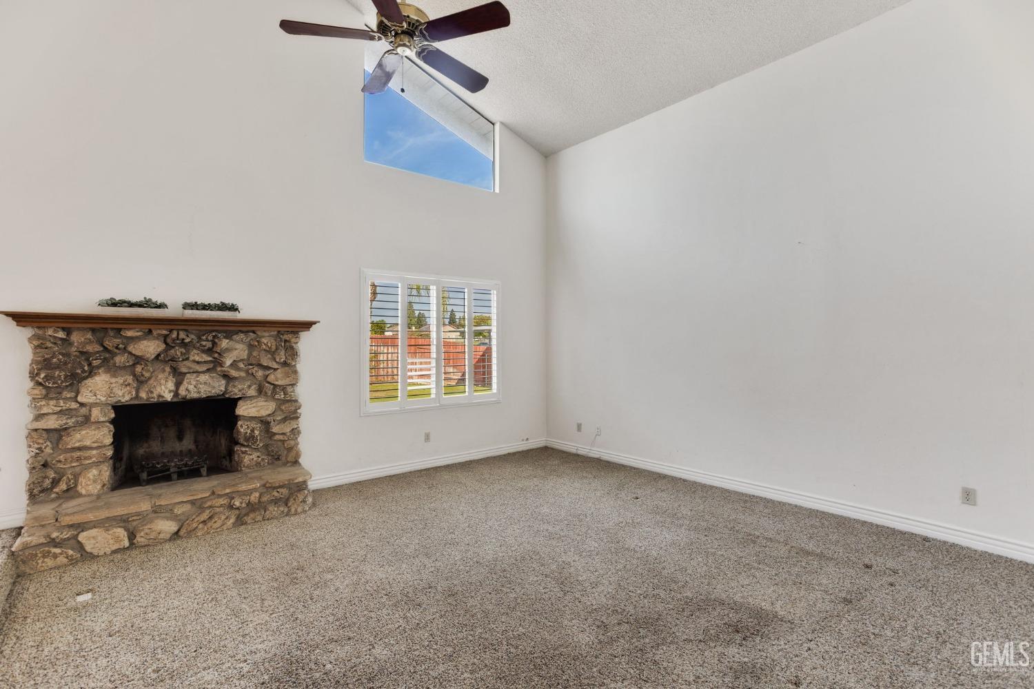 Undisclosed Address Bakersfield, CA 93306 - Photo 12 of 51 an empty room with ceiling fan and fireplace